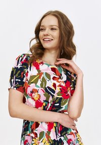 Sukienka w kwiatowy wzór z różnorodnymi kolorami, w tym różowym, czerwonym, zielonym i granatowym. Krótkie rękawy, okrągły dekolt i teksturowany materiał.