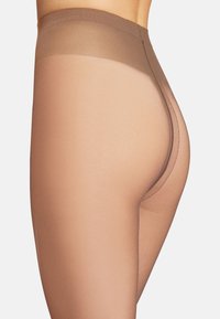 Genomskinliga köttfärgade strumpbyxor med en gradientövergång från mörkare till ljusare ton. Har en slät textur och ett brett, mjukt midjeband.