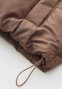 Brown padded jacket section with a smooth, matte texture. Features a cinch cord and stitching detail, showcasing a simple, structured design.