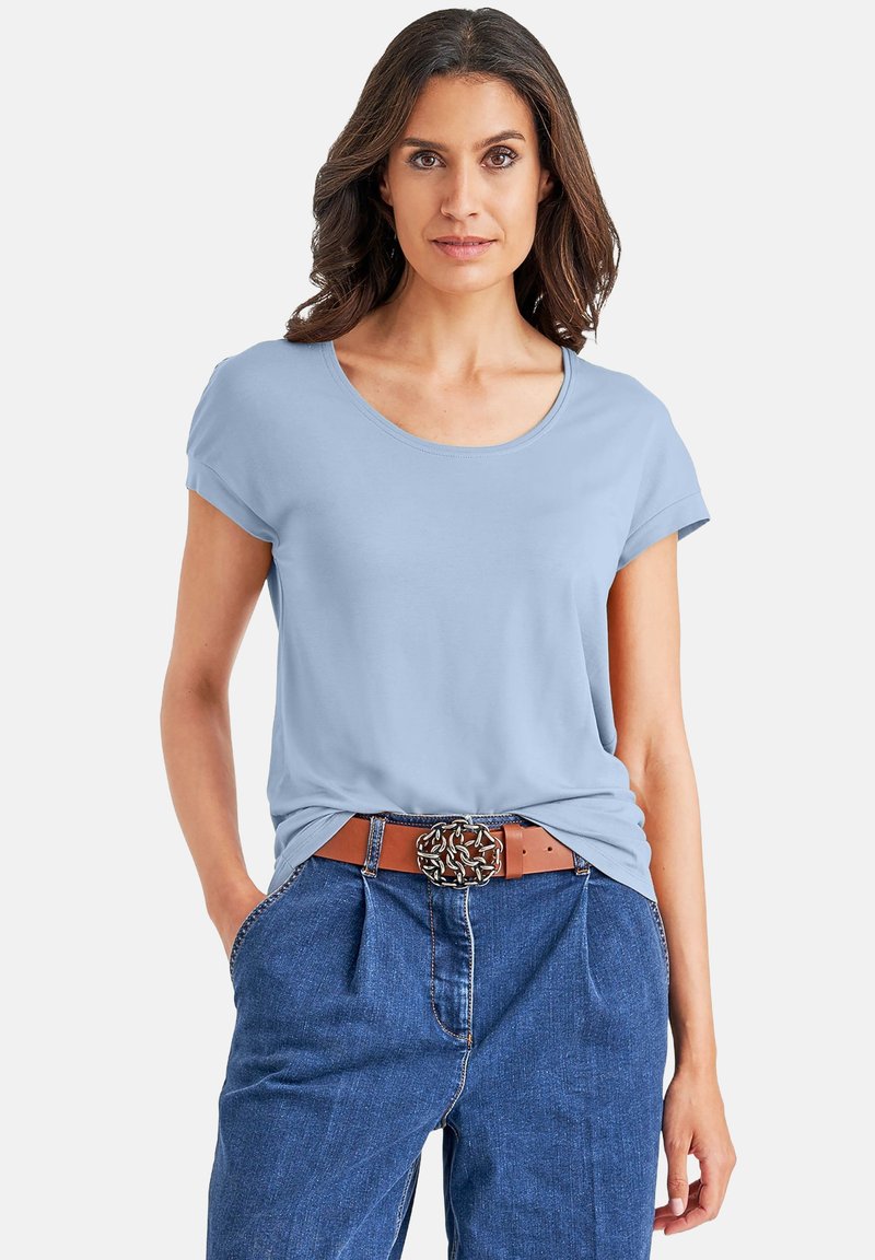  Lichtblauw T-shirt met korte mouwen en een ronde hals, gecombineerd met high-waisted jeans van denim en een bruine riem met een decoratieve gesp.
