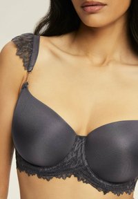 Szary stanik z gładkimi miseczkami, koronkowym wykończeniem i ozdobnymi ramiączkami. Tekstura kontrastuje między satyną a kwiatową koronką.