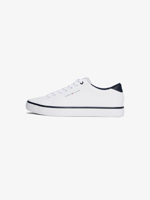 Białe sneakersy wykonane z materiału syntetycznego, cechujące się niskim fasonem, okrągłym noskiem, granatowymi akcentami oraz subtelnym logo po boku.