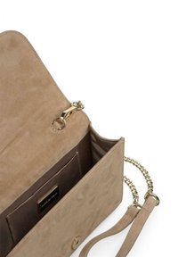 Bolso de ante beige con una correa de cadena dorada desmontable, que presenta un interior suave, un bolsillo y una etiqueta de la marca.