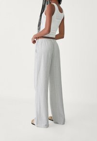 Gestreepte, lichtgewicht, grijze broek met een elastische tailleband en een wijde pijpontwerp. Zachte textuur, die comfort en bewegingsvrijheid biedt.
