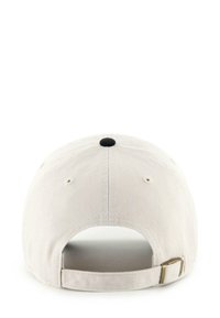 Beige baseball cap viewed from the back with adjustable fabric strap and metal buckle, featuring stitched ventilation eyelets and center button.