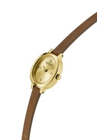 Montre dorée avec un boîtier ovale et un bracelet en cuir texturé marron. Comprend trois petits cristaux sur le cadran et une couronne sur le côté.