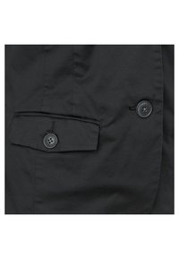 Svart tygjacka med en vänster bröstficka med knappstängning och ytterligare knappar för att fästa. Mjuk textur och skräddarsydd design.