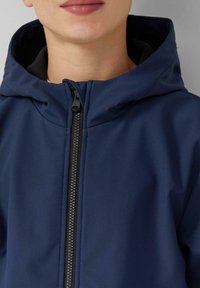 Granatowa kurtka softshell z zamkiem z przodu, kapturem i teksturowanym materiałem. Posiada kontrastowy czarny zamek i wysoki kołnierz.