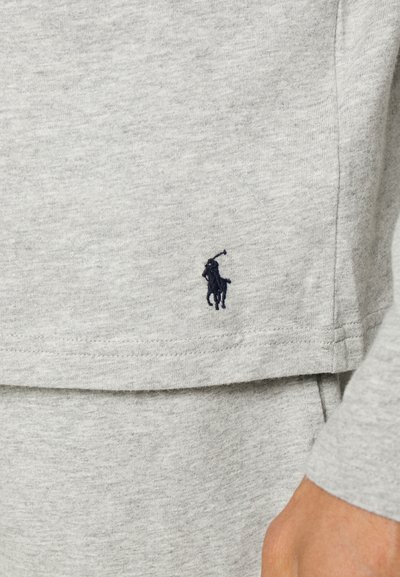 Szürke pamut pulóver, az alján egy kicsi, sötétkék hímzett polo logóval. Puha tapintás, egyszerű design és laza szabás jellemzi.
