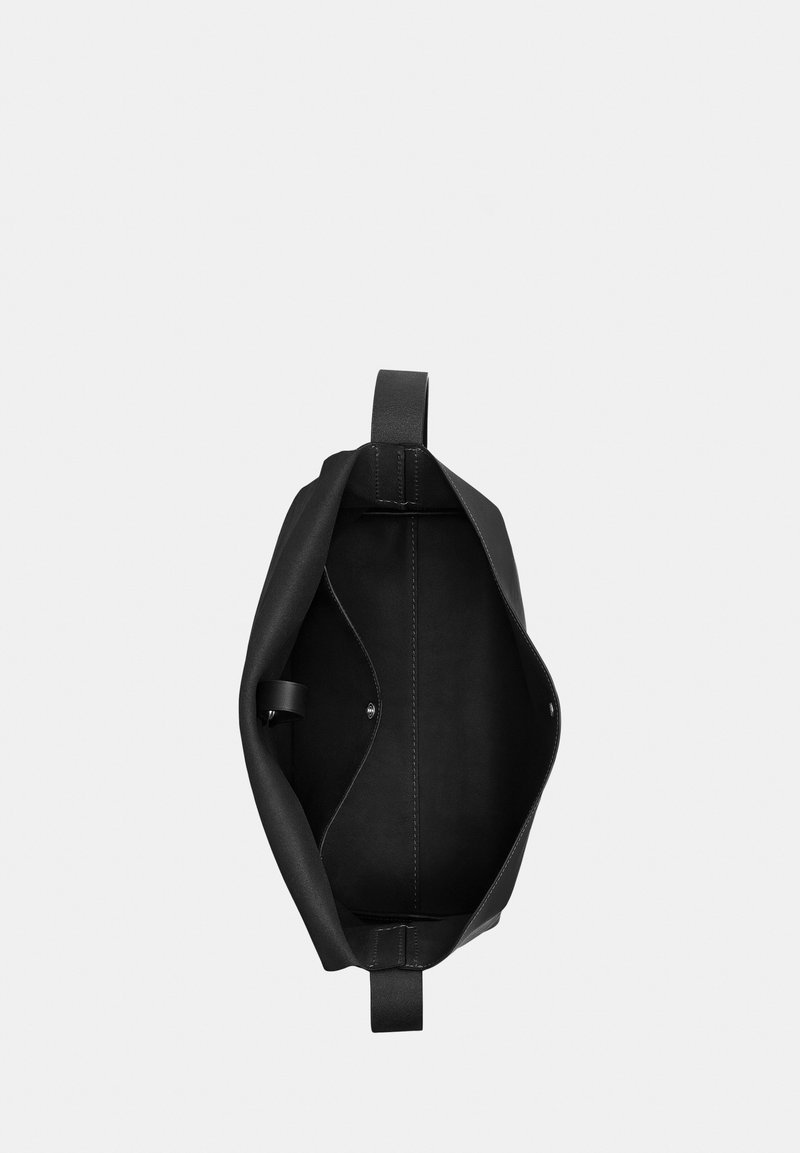 Zwarte leren totebag gezien van boven, met een open hoofdvak en magnetische drukknoopsluitingen aan beide zijden.