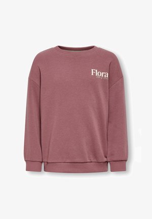 Roza pulover s spušenimi rameni, rebrastimi manšetami in robom. Na sprednji strani je napis "Flora" v svetli barvi. Gladka tekstura tkanine.