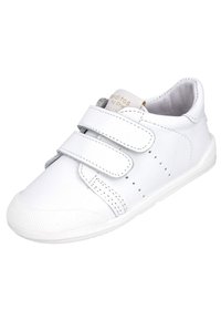 Zapatilla de cuero blanco con dos correas de Velcro. Presenta detalles perforados en el costado y una suela de goma texturizada. Forro interior suave.