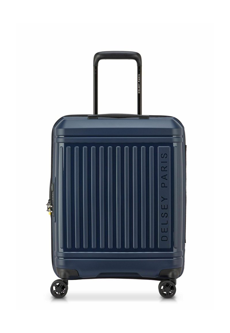 Maleta dura navy con surcos verticales, asa retractable negra, cuatro ruedas y el logo de Delsey Paris grabado en el lateral.