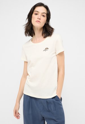 Cremefarbene T-Shirt mit kurzen Ärmeln, rundem Halsausschnitt und einem kleinen gestickten Croissant-Design auf der linken Brustseite.