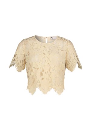 Crop top en dentelle beige avec motifs floraux, manches courtes et ourlet ondulé. Comprend un détail de fermeture au dos.