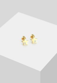 Orecchini a forma di stella dorata con una finitura lucida e un piccolo gemstone trasparente al centro. Design compatto, adatto per un look casual.