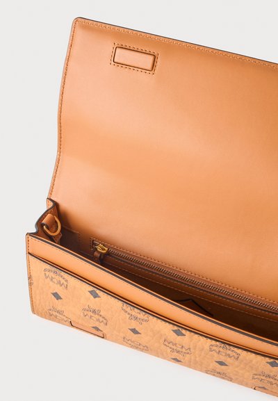 Pochette en cuir fauve avec motif logo MCM à l'extérieur, rabat ouvert montrant une poche intérieure zippée et un compartiment spacieux.