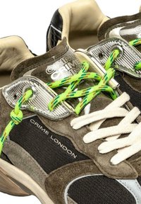 Sneaker Crime London in suede marrone e rete nera, con lacci a fantasia bianchi e verde neon e dettagli in occhioletto metallico.