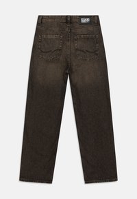Tumed pruun denim teksad sirge lõikega, millel on kaks tagakotitaskut ja brändi tähis vööl. Tekstuuriga kangas kerge fade-iga.