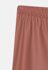 Měkk�á růžová, pružná tkanina s nařaseným elastickým pasem, ukazující hladký texture a jednoduchý design. Vhodné pro volnočasové nošení.