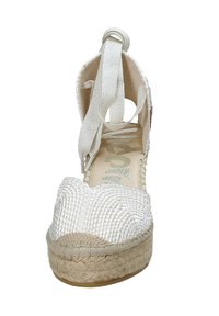 Sandalo espadrilles bianco con tomaia intrecciata, punta arrotondata e lacci alla caviglia. Presenta una suola in juta e accenti in pelle liscia.