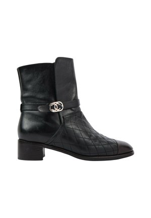 Bottine en cuir noir à petit talon, motif matelassé sur le devant et boucle argentée avec logo double-C sur la lanière latérale.