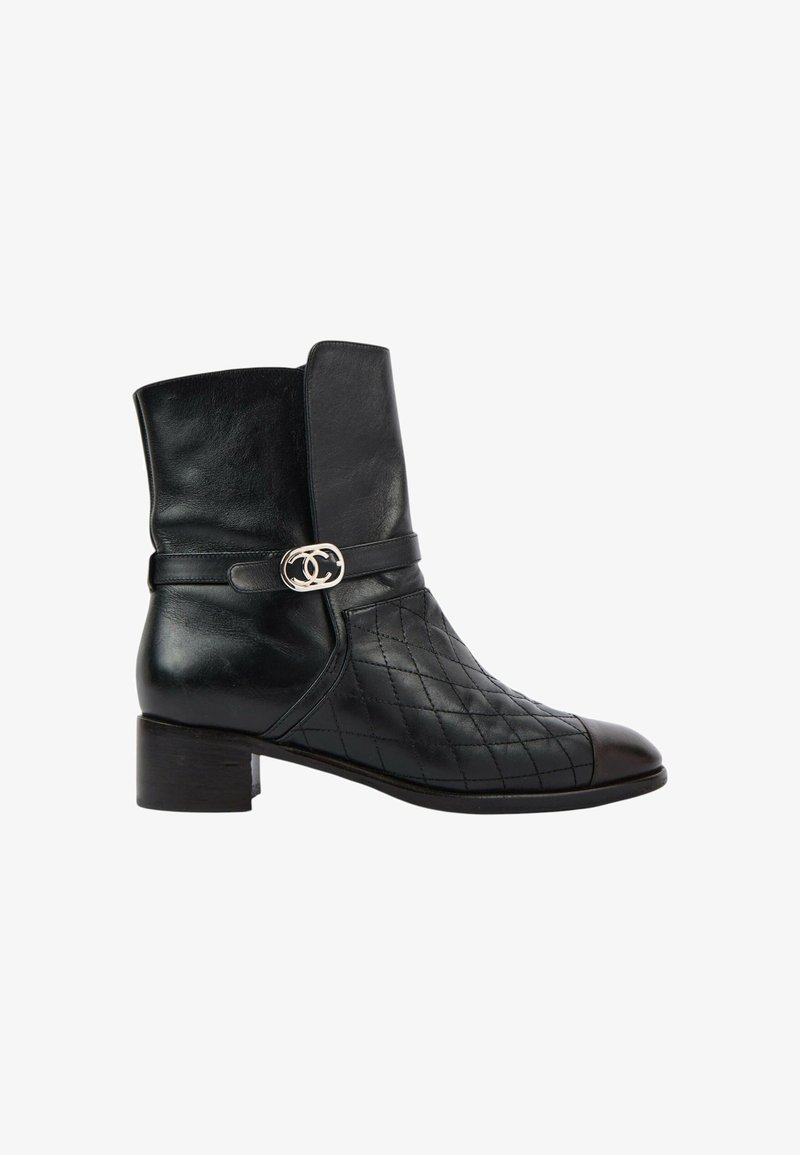 Bottine en cuir noir à petit talon, motif matelassé sur le devant et boucle argentée avec logo double-C sur la lanière latérale.