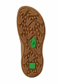 Semelle de chaussure marron avec des empreintes d'oiseaux en relief et un motif de petits cercles, arborant deux logos verts : un pied stylisé et une grenouille.