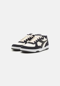 Sneaker navy e crema con una combinazione di materiali scamosciati e sintetici, caratterizzati da una suola in gomma bianca e accenti in contrasto.
