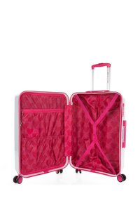 Maleta rígida en blanco con detalles en rosa, que cuenta con un interior abierto, forro de tela estampada, bolsillo con cremallera y correas elásticas para la organización.