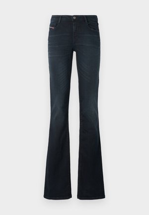 Tamsiai mėlyni flared džinsai su lygiu paviršiumi, penkių kišenių dizainu ir mygtukų uždarymu ties liemeniu. Yra subtilus siuvinėjimo detalės.