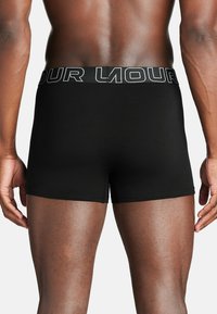 Črne bokserice iz gladkega materiala, z širokim elastičnim pasom s kontrastnim napisom. Oblikovanje je prilegajoče in brezšivno.