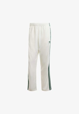 White athletic pants with green side stripes, elastic waistband, and a logo on the upper left side. Made from lightweight fabric.
