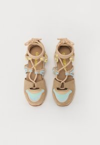 Sandali in suede beige con design a taglio per le dita e il tallone, dotati di fasce elastiche blu e gialle, dettagli testurizzati e suola a contrasto.
