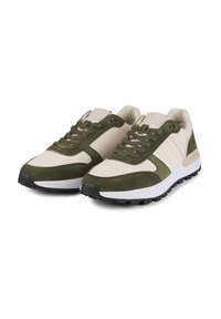 Lichte sneakers met een mix van beige canvas en donkergroen suede. Voorzien van zwarte rubberen zolen, opvallende veters en branding op de tong.