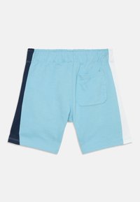 Calções azul claros com painéis laterais em azul marinho e branco, cintura elástica e um bolso nas costas. Feitos de um tecido macio com uma textura suave.