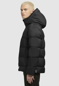 Schwarze aufgeplusterte Jacke mit Kapuze, mit einem gesteppten Design, Reißverschluss-Seitentäschchen und elastischen Manschetten. Glatte Stoffstruktur.
