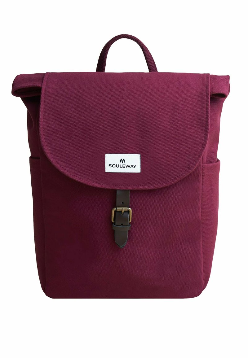 Vinröd kanvas ryggsäck med en vikbar flap, läderknäppning och sidofickor. Har ett handtag på toppen och en logotyp patch på framsidan.