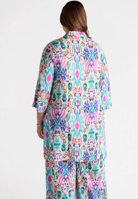 Kimono leggero e leggermente strutturato con fantasie pastello, caratterizzato da disegni floreali e abstract. Maniche corte e vestibilità morbida.