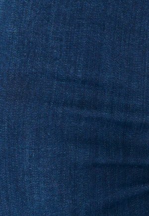 Texture di tessuto denim blu scuro con trama diagonale visibile e lievi variazioni di tonalità.