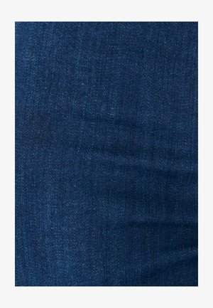 Texture di tessuto denim blu scuro con trama diagonale visibile e lievi variazioni di tonalità.