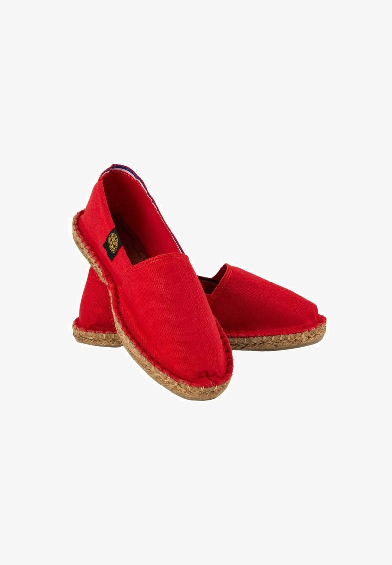 Espadrilles en toile rouge avec une semelle plate, une bordure en jute tressé et un design à enfiler. Bout légèrement pointu, texture de tissu léger.