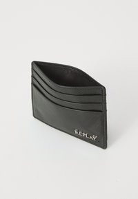 Černý kožený držák na karty se čtyřmi sloty, hladký povrch, decentní stříbrné značení a elegantní obdélníkový tvar.
