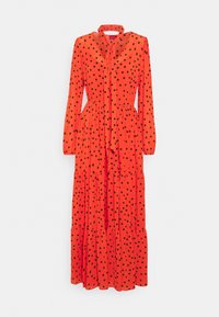 Robe longue à manches longues orange vif à pois noirs, jupe à volants et nœud noué au col.