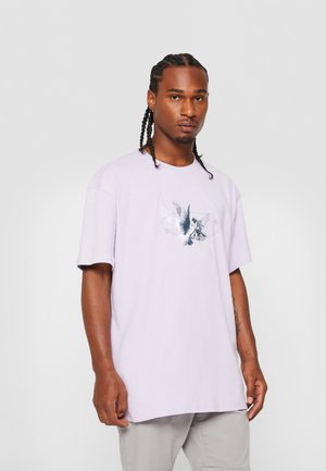 Light purple cotton t-shirt with short sleeves, featuring a graphic design of birds and a figure in the center. Flat hem and relaxed fit.