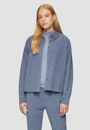 Lichtblauwe corduroy overhemdenjack met een kraaghals, knoopsluiting aan de voorkant en lange mouwen, gecombineerd met een bijpassend blauw top en broek.