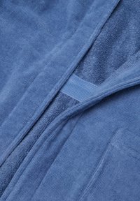Blauwe badjas van terrykatoen met een zachte textuur, voorzien van een sjaalkraag, riemlussen en een gestikte pocket. De stof heeft een luxe, absorberende kwaliteit.