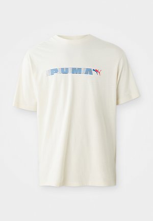 T-shirt de algodão na cor creme com mangas curtas. Apresenta um logótipo e design gráfico em azul e vermelho da "PUMA" no centro.