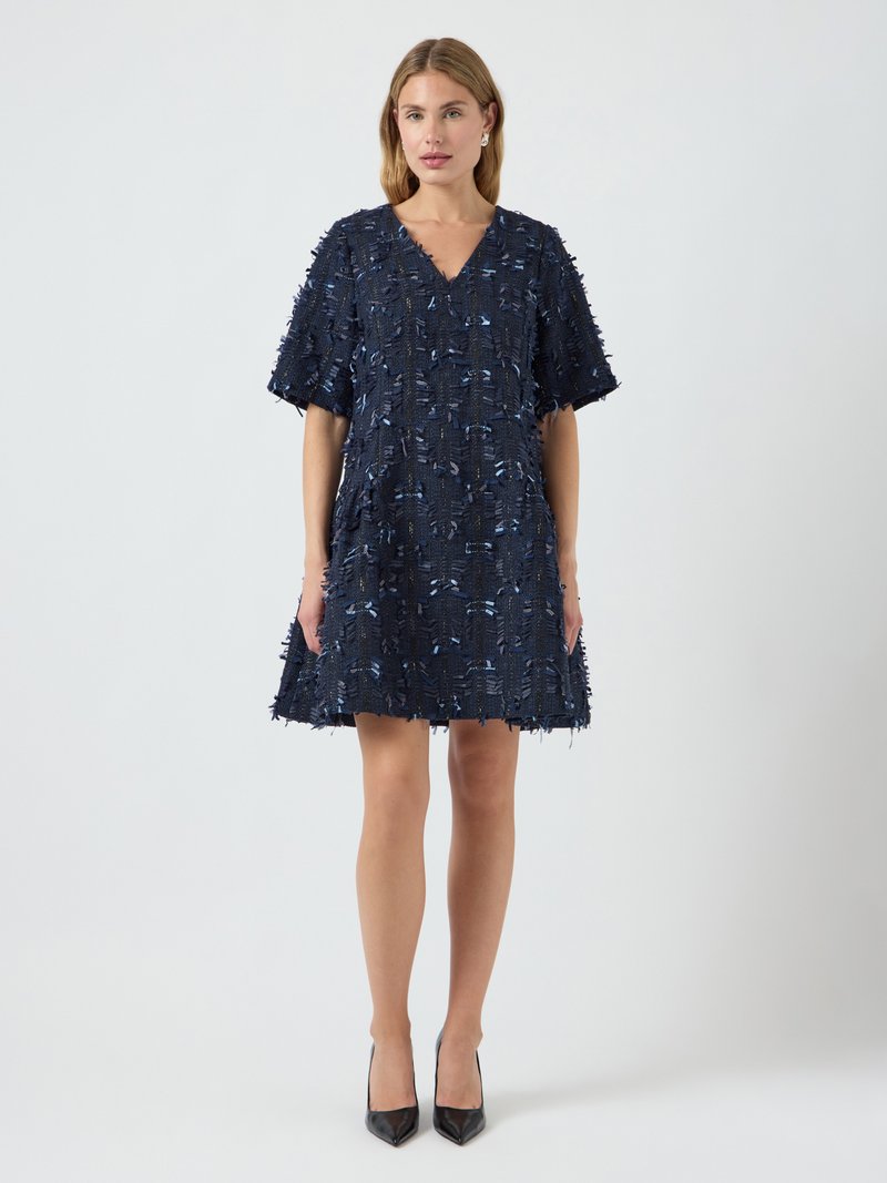 Tamsiai mėlyna suknelė su V formos iškirpte, trumpomis rankovėmis, tekstūruota medžiaga, dekoruota šviesiai mėlynomis akcentais ir fringo detalėmis, pločio gale.