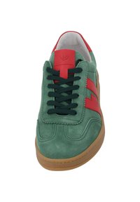 Gröna mockasneakers med ett rött rand och gröna snörningar. Har en sydd design och en tanfärgad gummisula. Vit invändig foder.